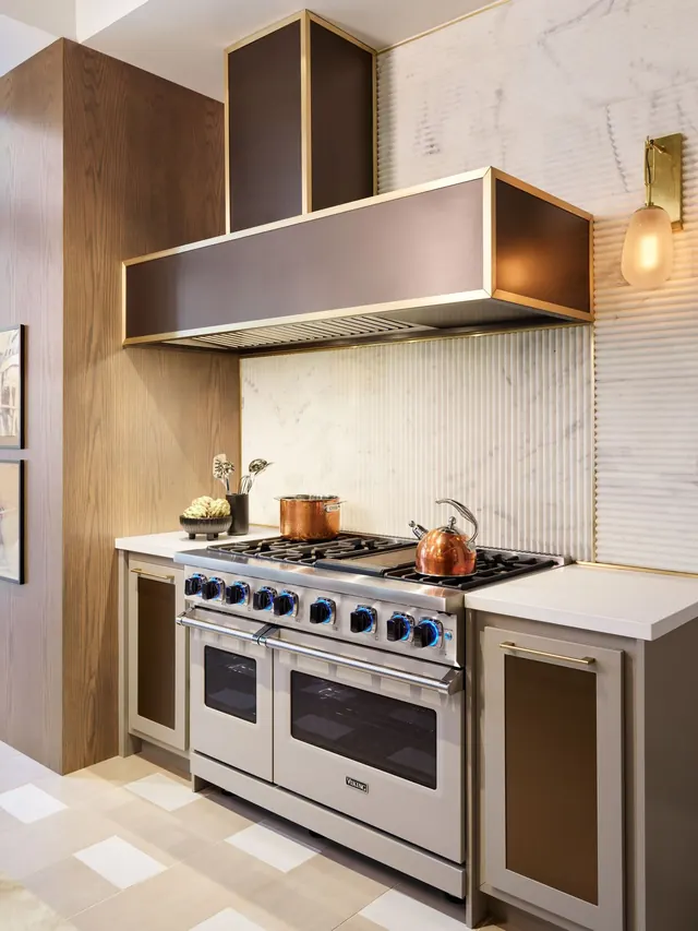 Dual-fuel range with a bronze hood in a modern kitchen