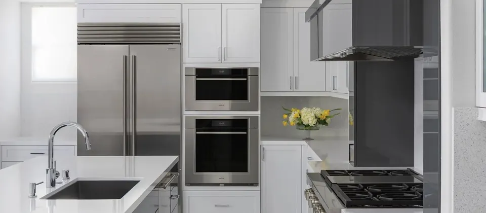 Kitchen with built-in refrigeration, wall ovens and a cooktop